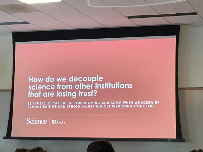 Holden Thorp lecture slide a This photo shows a lecture slide with a red background and reads "How do we decouple science from other institutions that are losing trust?"