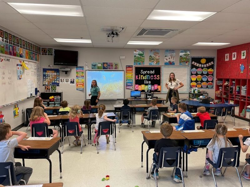 Virginia Tech graduate students Samantha Brooks (in front of screen) and Maddie Betts talked to kindergarten children about a fish species called the Bluehead Chub during a May 2023 Girls Launch! visit. Photo by Carrie Kroehler for Virginia Tech. 