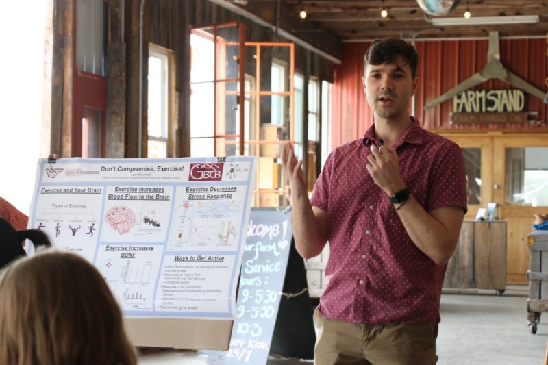 Jack Browning speaks next to his poster about exercise.