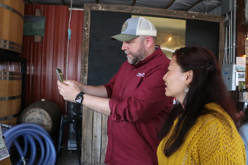 Two participants look at a bear video on a smartphone.