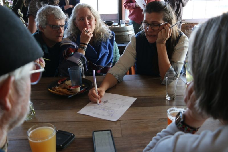 A group of participants fill out a trivia sheet together.