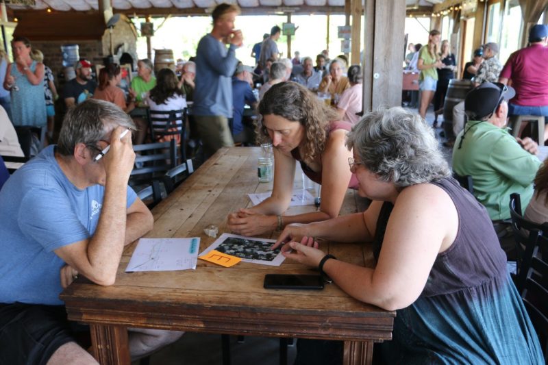 This photo shows a group of three people discussing what they are noticing as they study the rock.