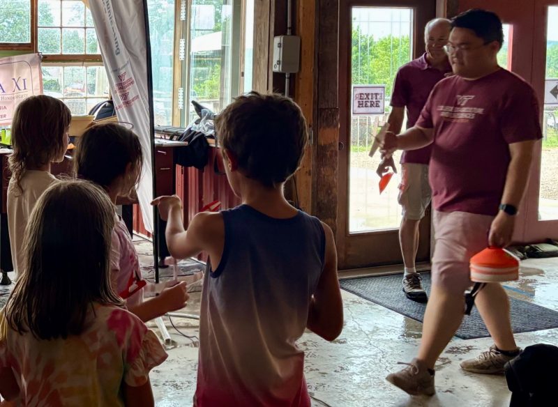 July SoT 5 Children watch as a person places cones in preparation for a distance contest.