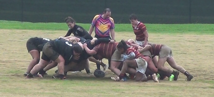 This photo shows a rugby scrum--a group of about ten players entangled on the field.