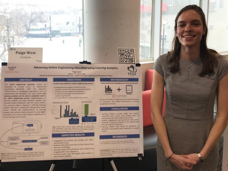 This photo shows a young light-skinned woman with below-the-shoulders brown hair, a short-sleeved patterned dress, and a big smile. She is standing next to a research poster with her name (Paige West) on it along with a title "Advancing Online Engineering Education Using Learning Analytics."