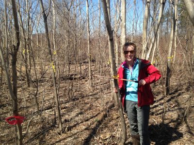This photo shows Rachel Brooks standing among small (and leafless) trees. Photo credit: Andy Dechaine.