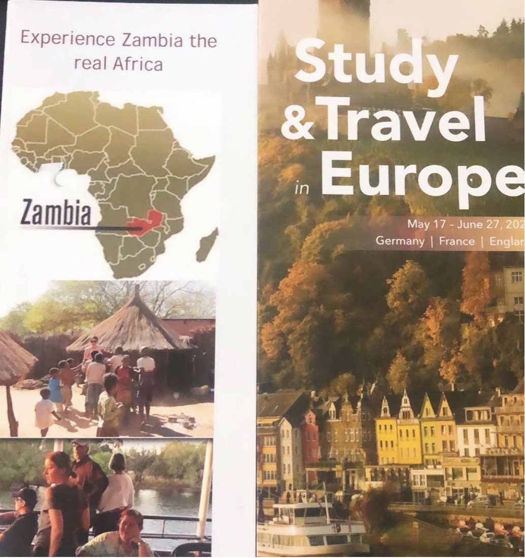 This image shows two brochures for study abroad programs. The brochure for Zambia reads "Experience Zambia the real Africa" and shows a photo of white people on a boat and of Black people near a grass-roofed hut.  The other brochure reads "Study & Travel in Europe" and shows a river cruiser and a city.