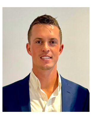 A headshot of a caucasian male with a dark blue blazer and white dress shirt. 