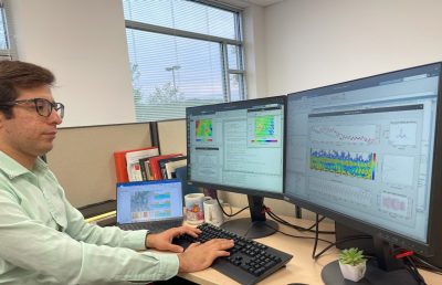 Geosciences graduate student Mohammad Khorrami studies the effects of groundwater withdrawal on land subsidence. He is typing while there are two screens to display the information. 