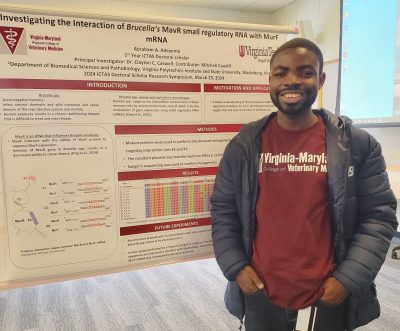 Abraham Adeyemo stands proudly in front of his poster showcasing his work on interactions between different types of mRNA. Photo courtesy of Abraham Adeyemo.