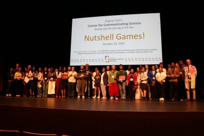 All Nutshell Games participants line up across the stage in front of a projected image that says "Nutshell Games! October 23, 2025"