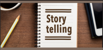 This photo shows a desk with a pencil and a ruled notebook with the words "Story telling" on it. 